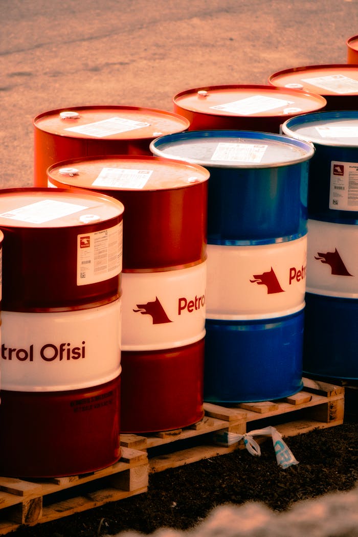 A collection of red and blue oil barrels labeled Petrol Ofisi in an outdoor industrial setting in Turkey.